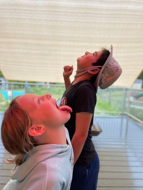 A boy and a girl are sticking their tongues out.