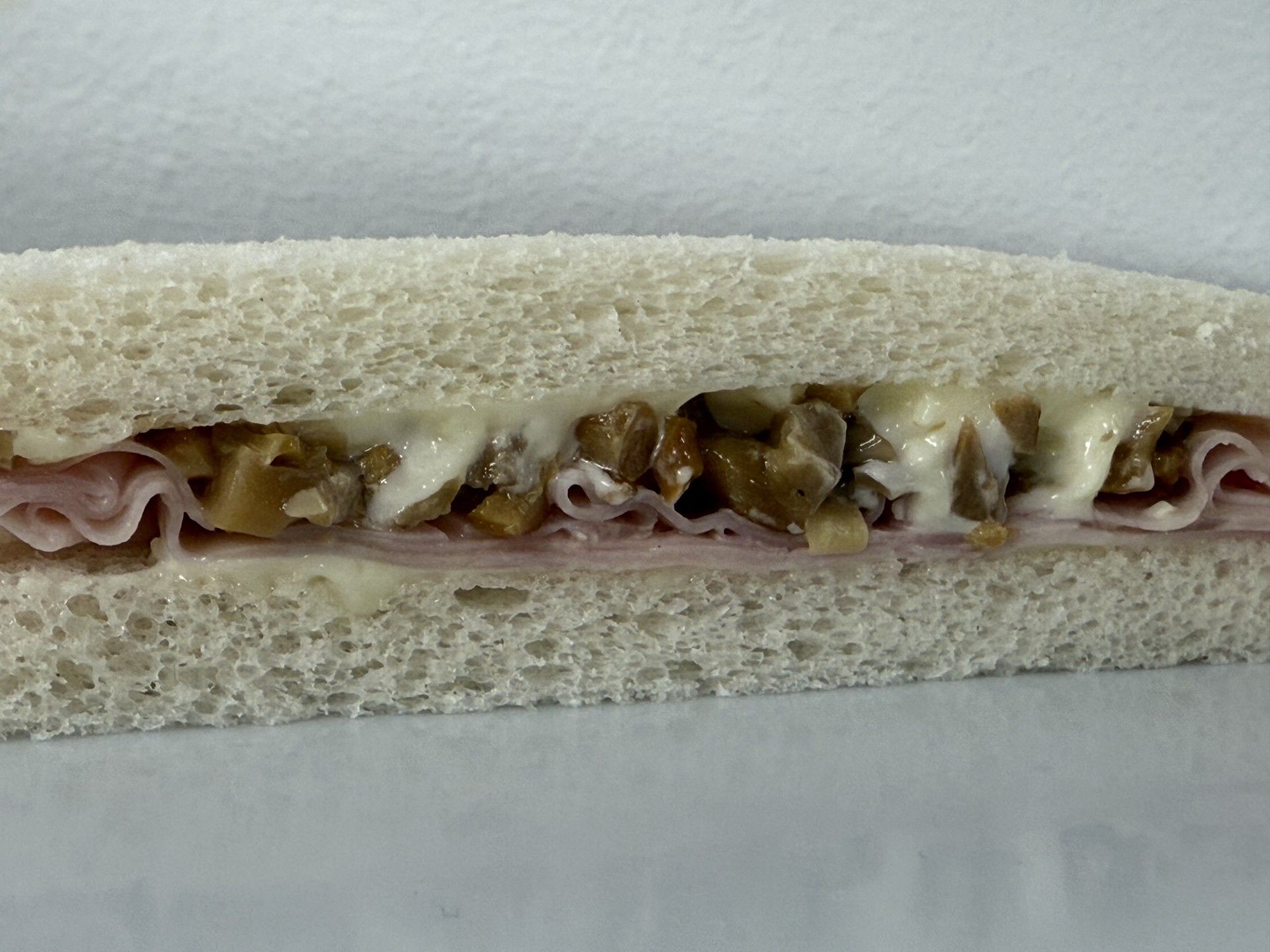 Panino con prosciutto e funghi su pane bianco, con maionese.