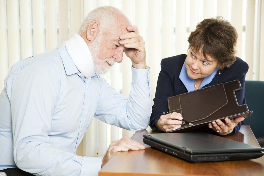 a female attorney speaking with a distressed client in a neck brace