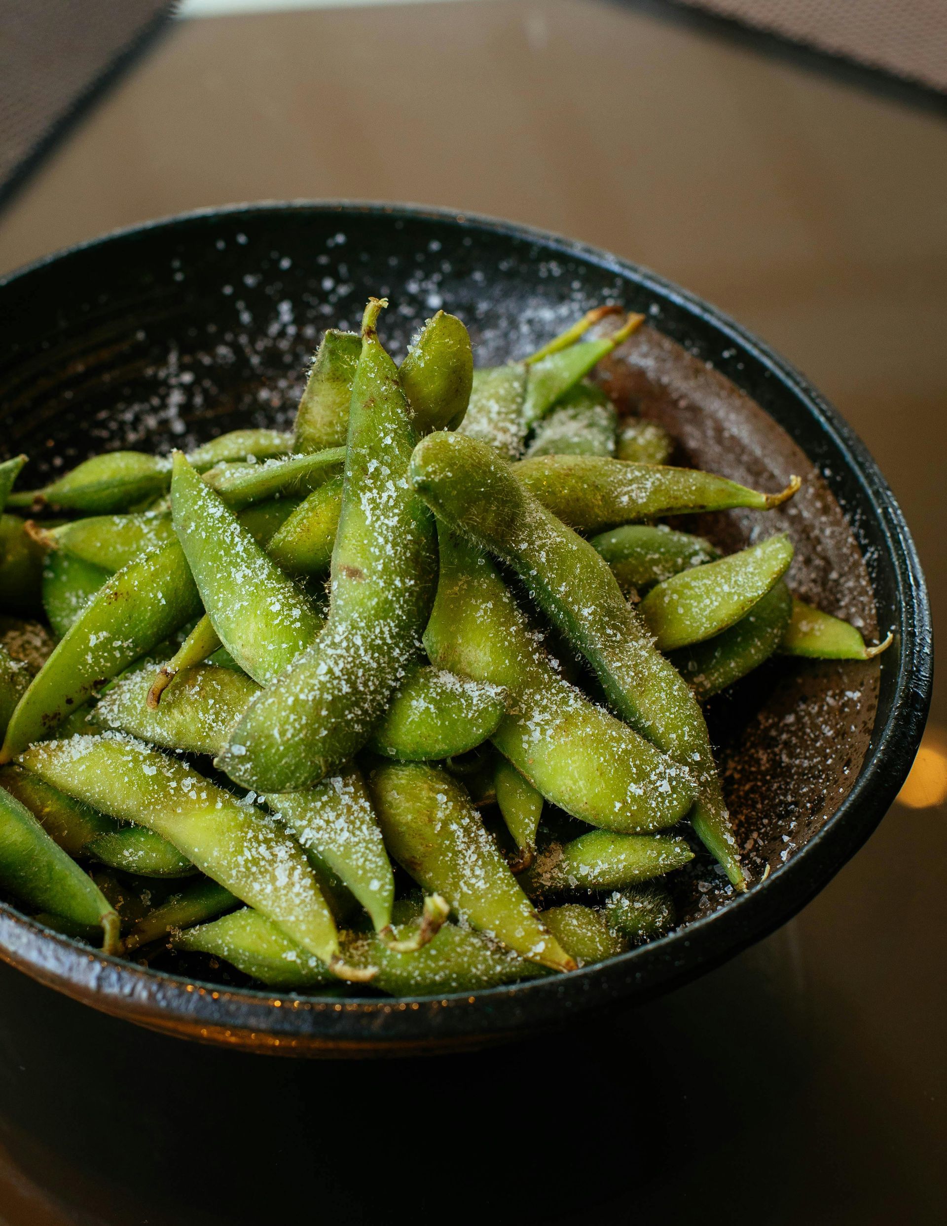 Edamame in a dark brown bowl