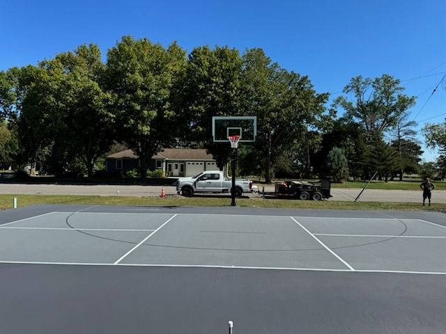 A white truck is parked on the side of a basketball court.