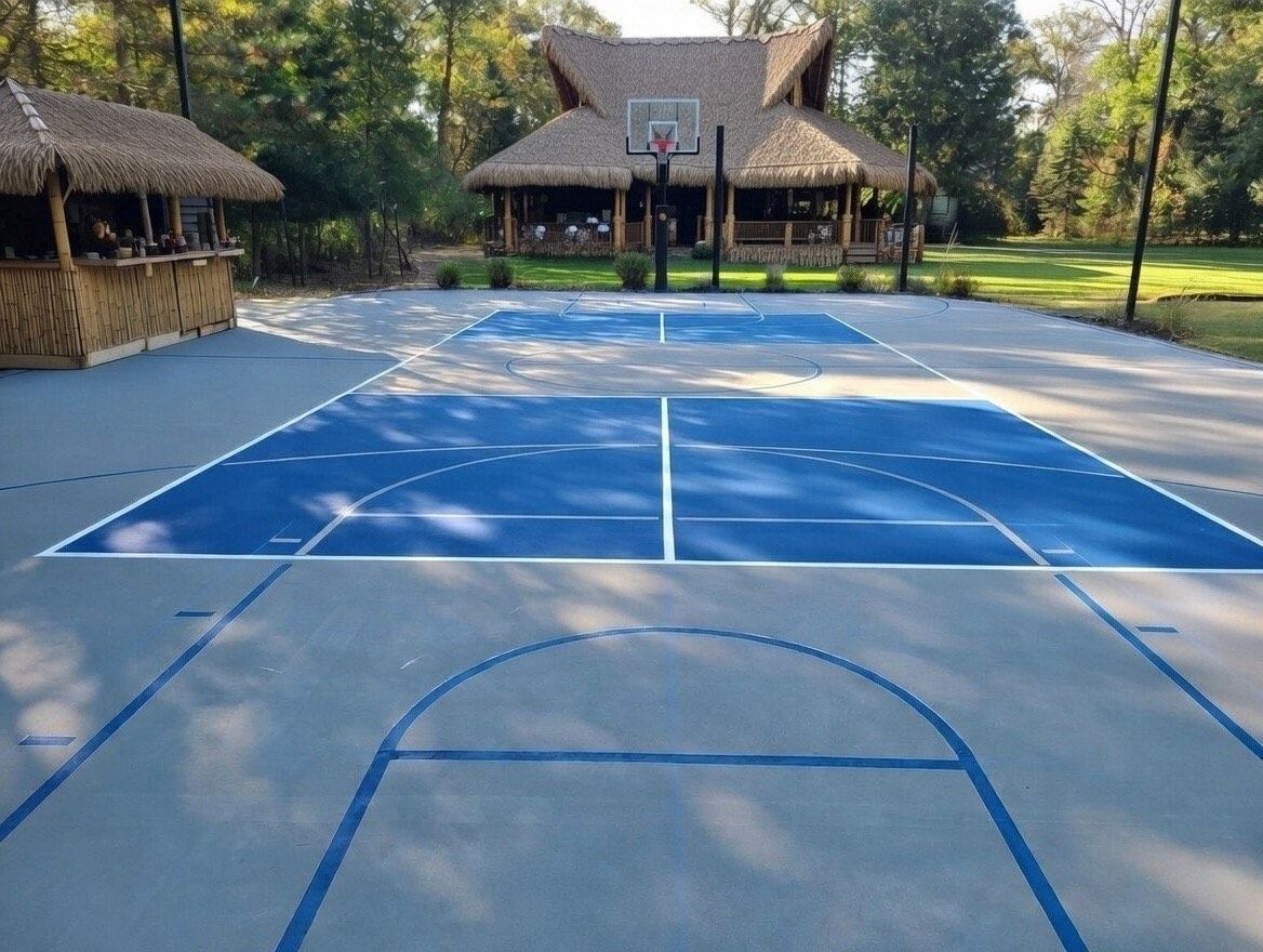 Pickleball court with blue and red playing surface, nets, and building in background.