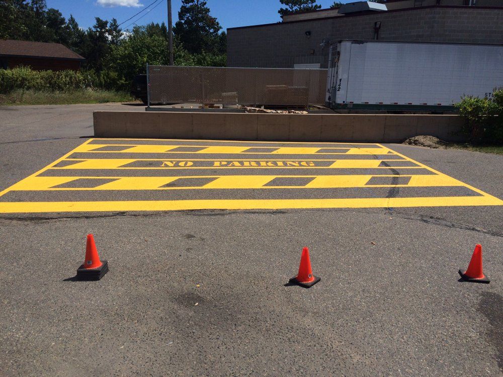 Three orange cones are sitting on the side of a road