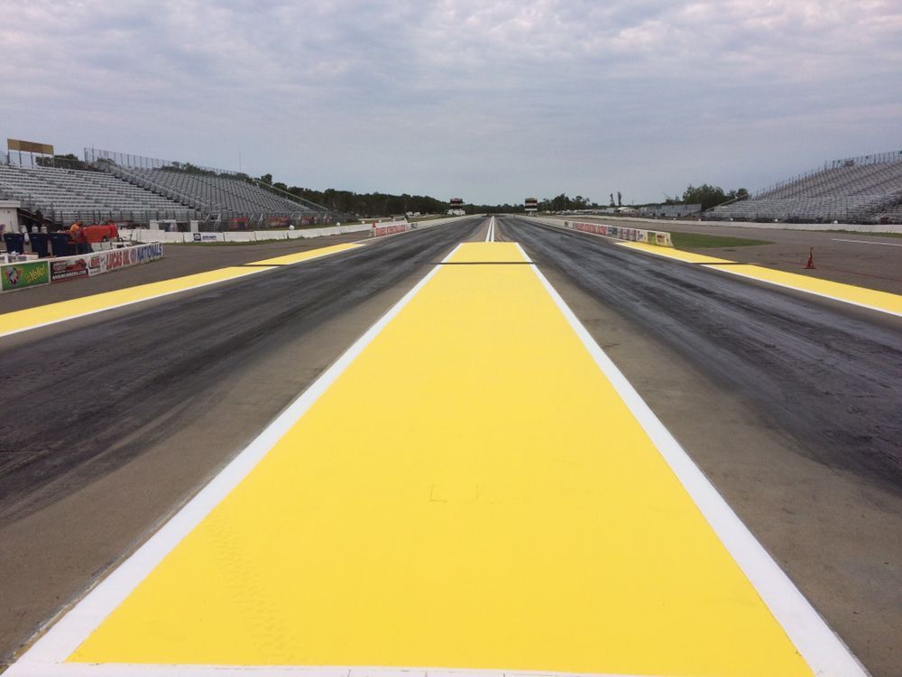 A race track with a yellow line and white lines