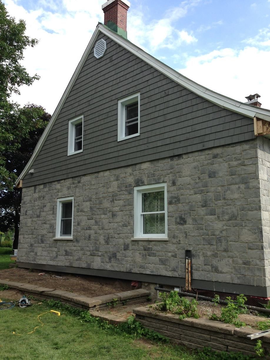Une grande maison en brique avec une cheminée au sommet.