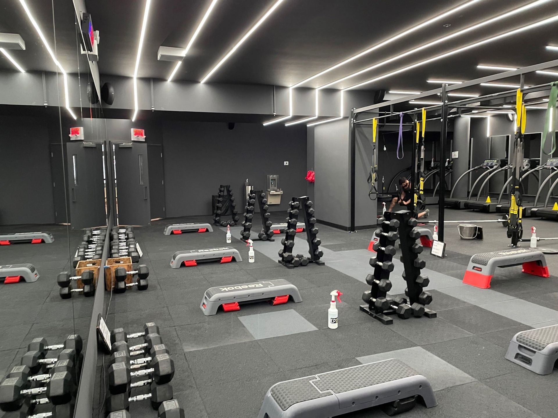 Une grande salle de sport avec beaucoup d'haltères et de bancs