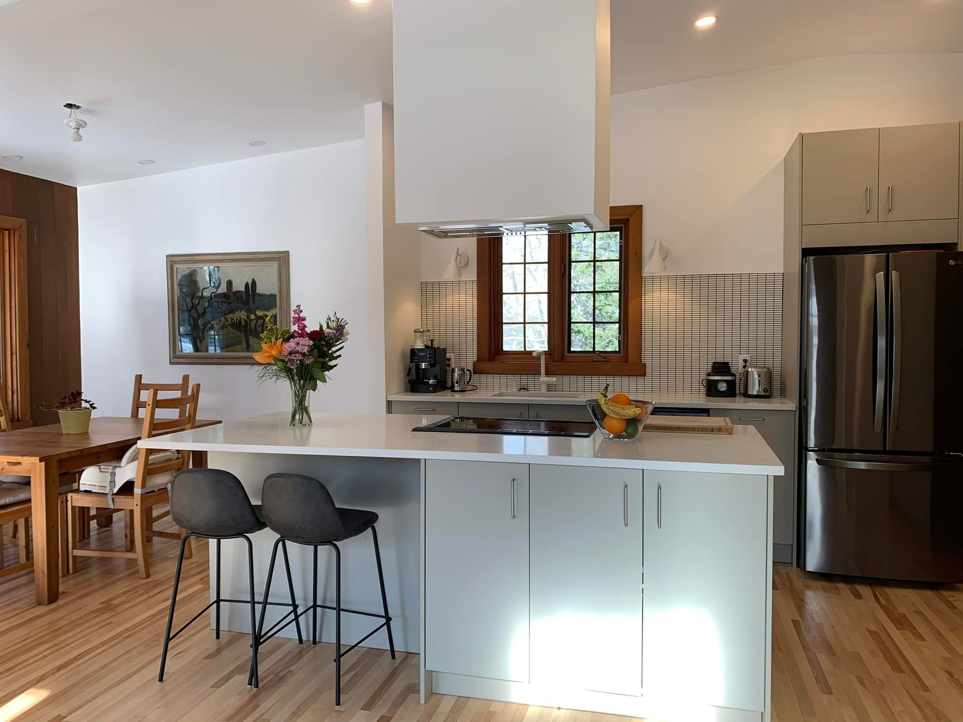 Une cuisine avec un réfrigérateur en inox et une table et des chaises