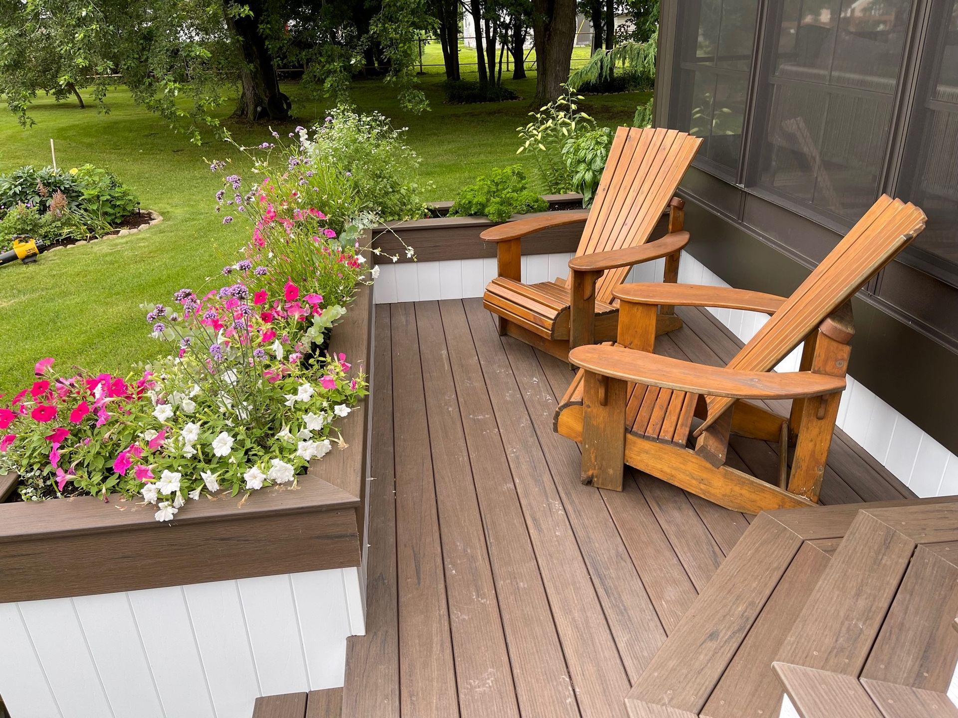 Deux chaises en bois sont assises sur une terrasse en bois.