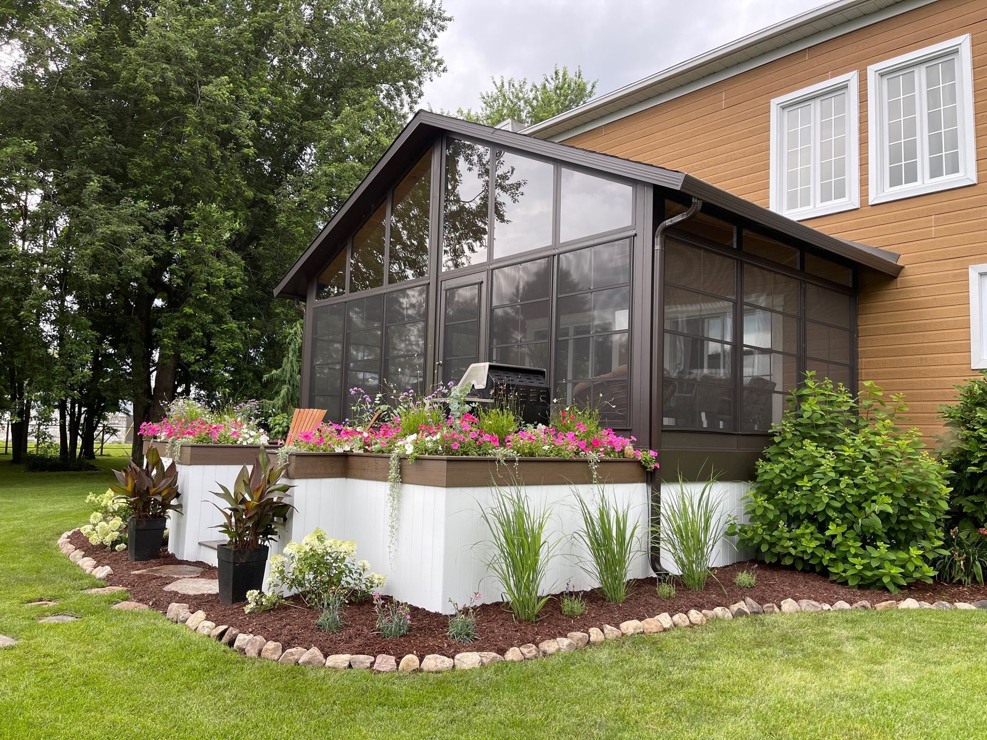 Il y a une véranda grillagée dans la cour d'une maison.