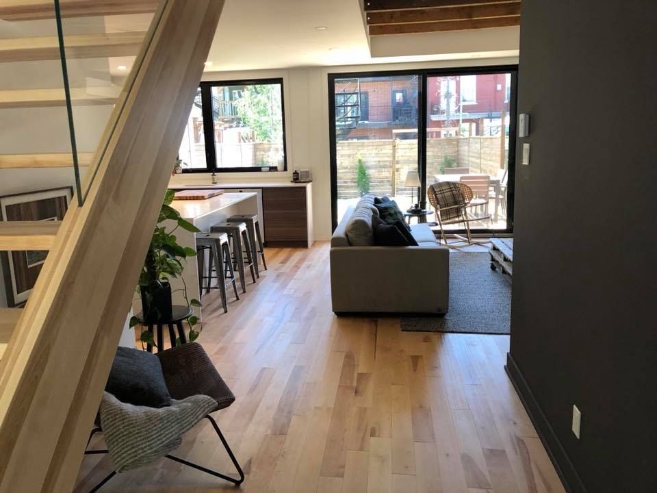 Un salon avec un canapé, des chaises et des escaliers