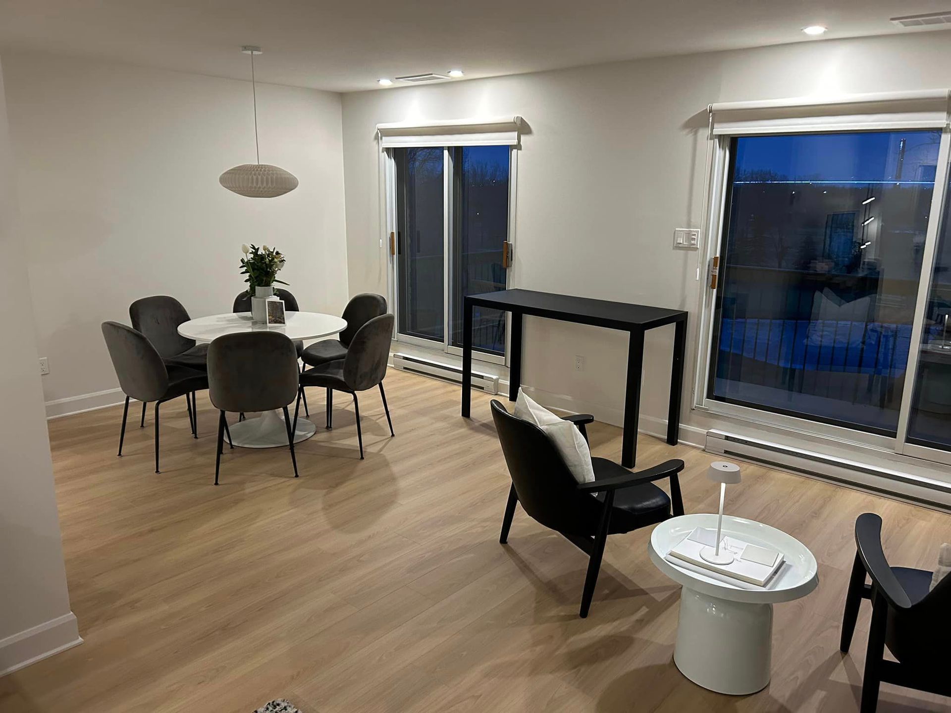 Un salon avec une table , des chaises et une porte coulissante vitrée.