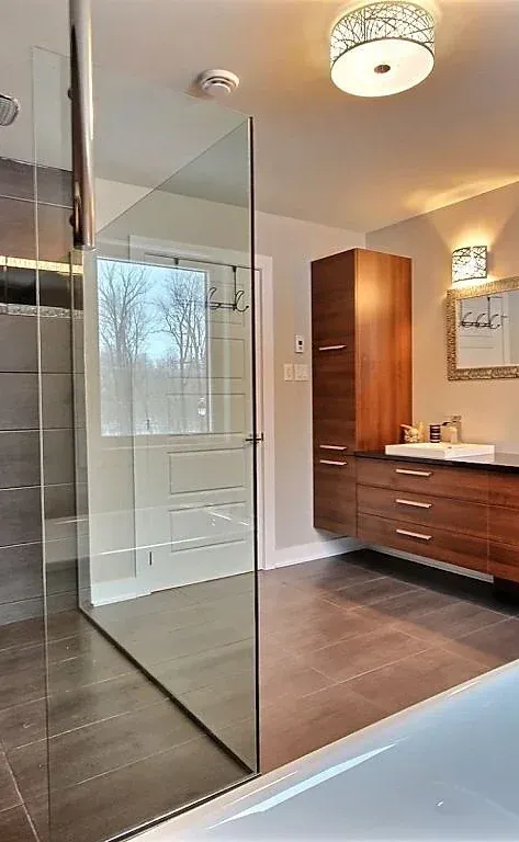 Une salle d'eau avec douche à l'italienne, lavabo et miroir.