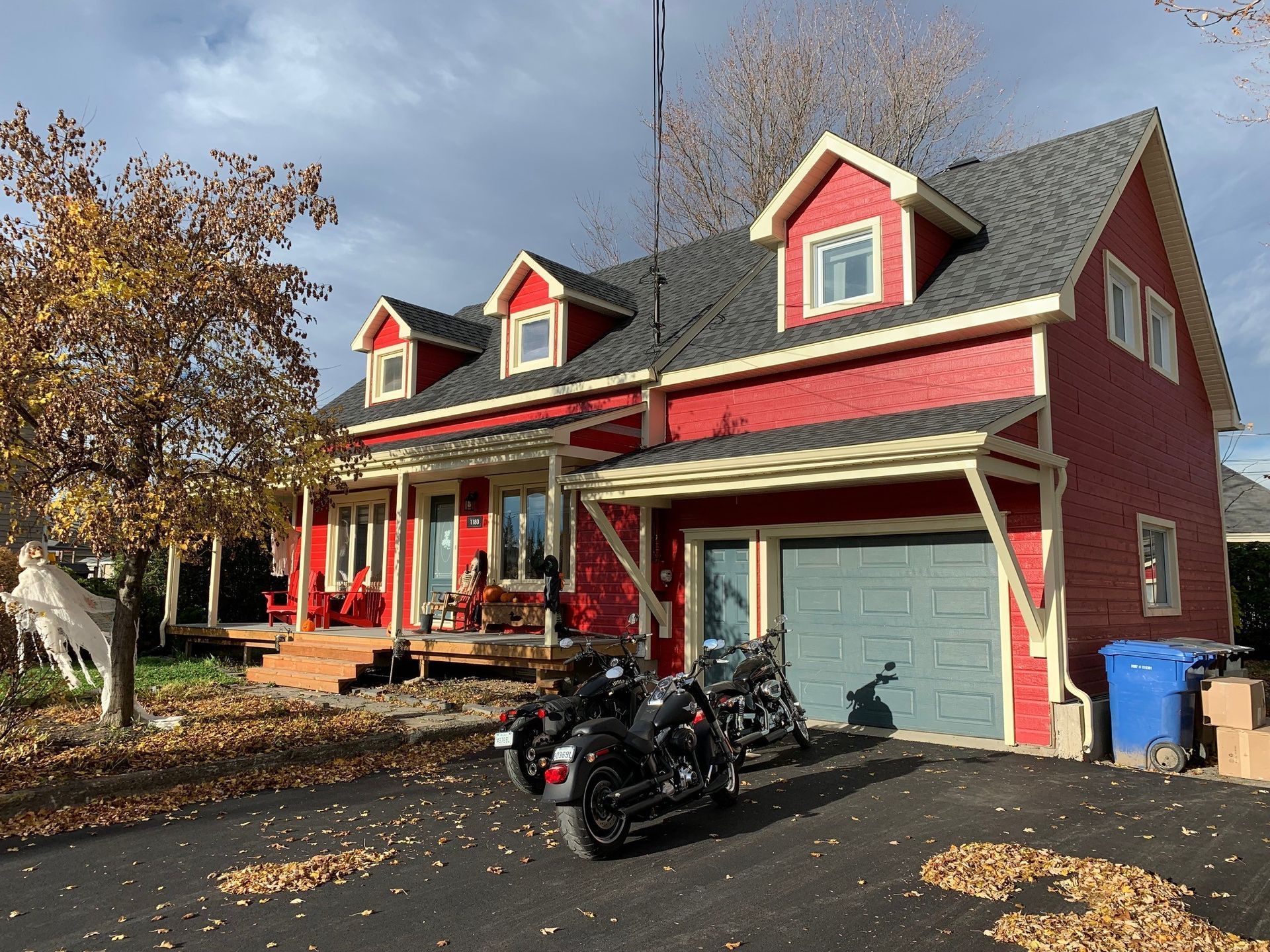 Deux motos sont garées devant une maison rouge