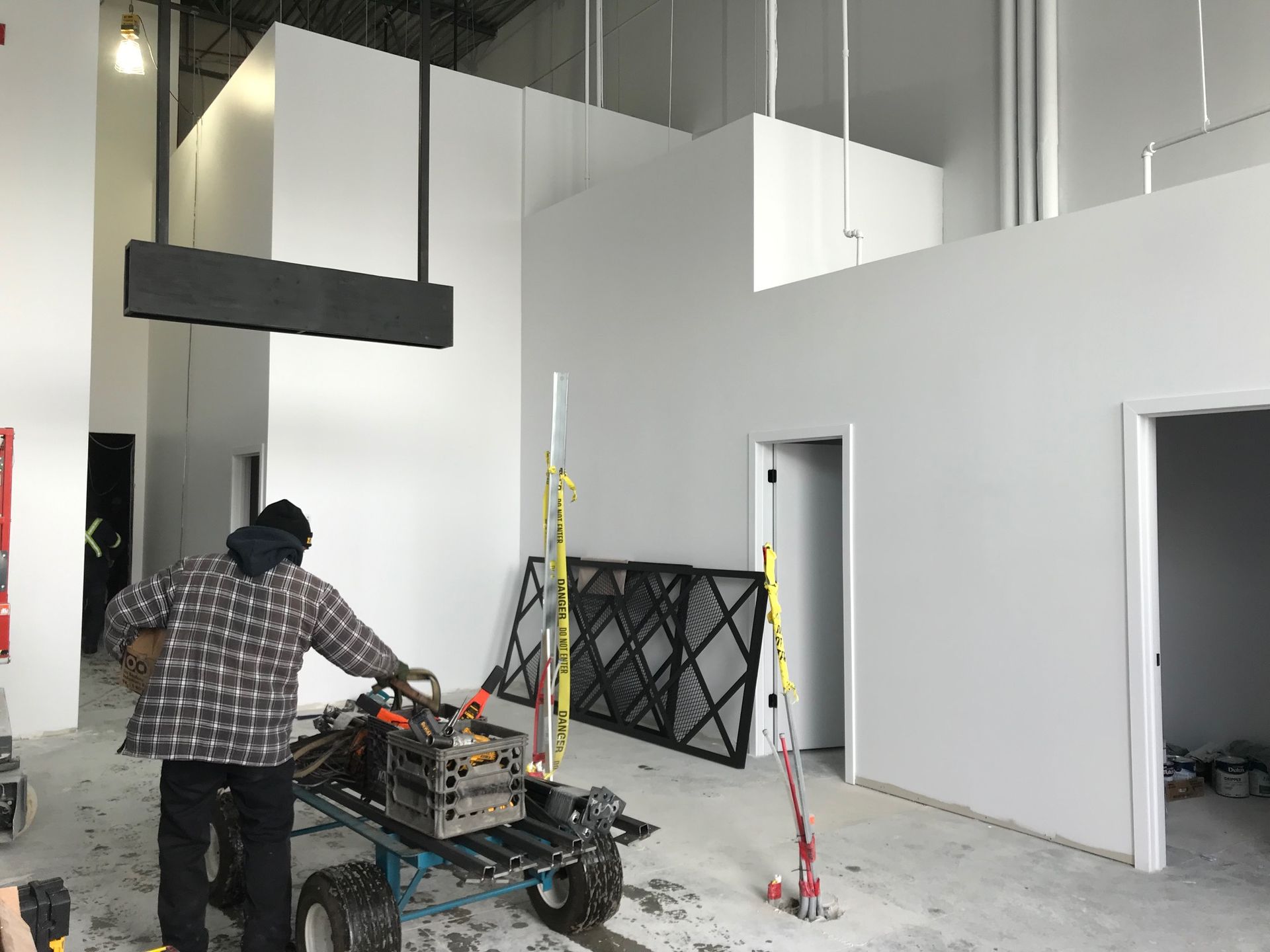 Personne dans une zone de construction utilisant des machines, travaillant à proximité de murs peints.