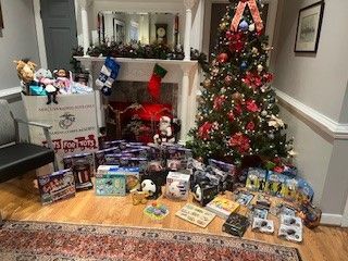 A living room filled with lots of toys and a christmas tree.