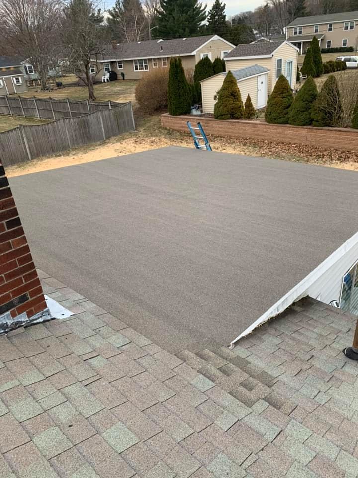 A carpet is being installed on the roof of a house.