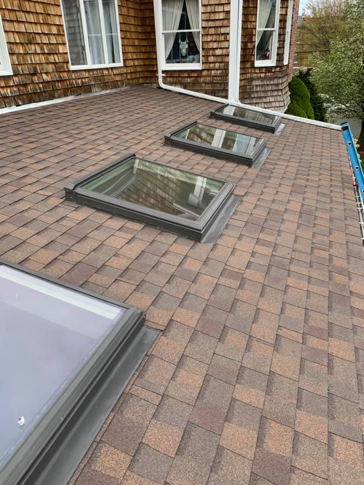 There are three skylights on the roof of a house.