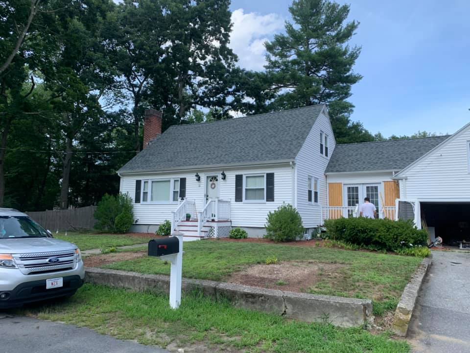 A white house with a car parked in front of it