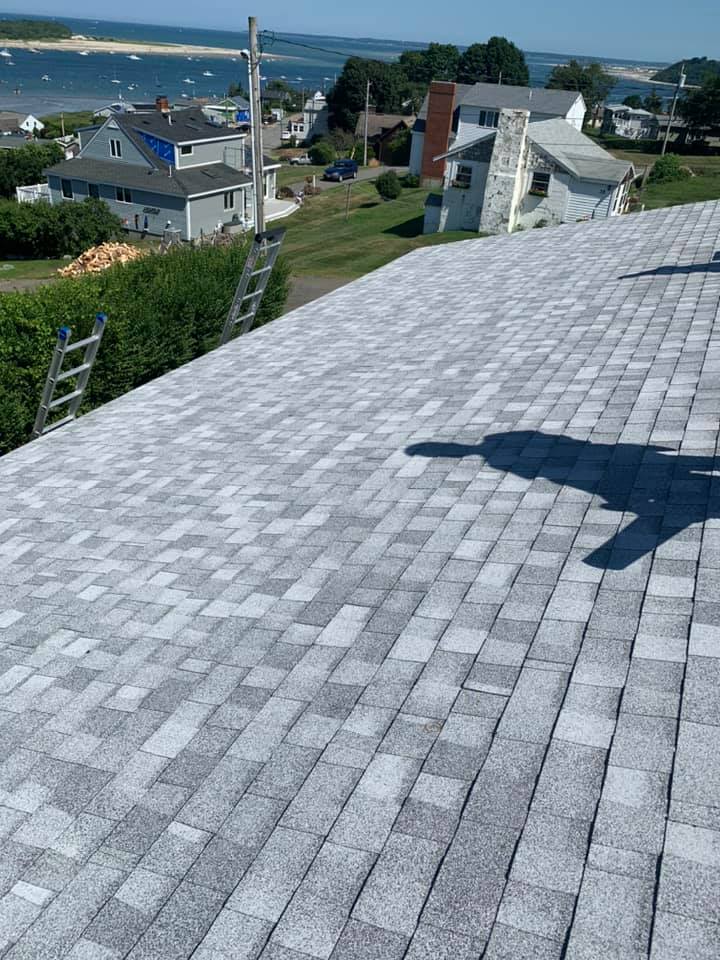 A roof with a view of the ocean and a ladder on it.