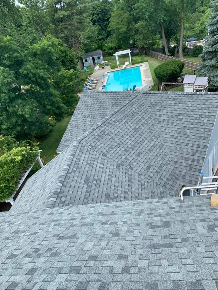 An aerial view of a roof with a pool in the background.
