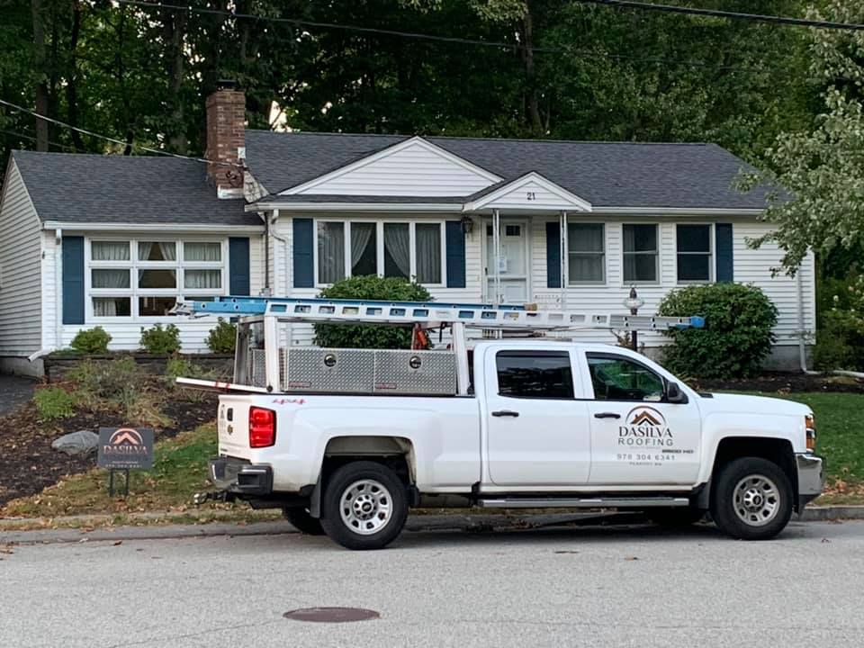 A white truck is parked in front of a house.