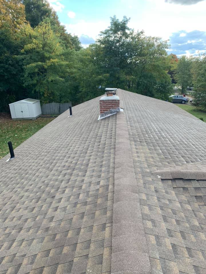 The roof of a house with a chimney on top of it.