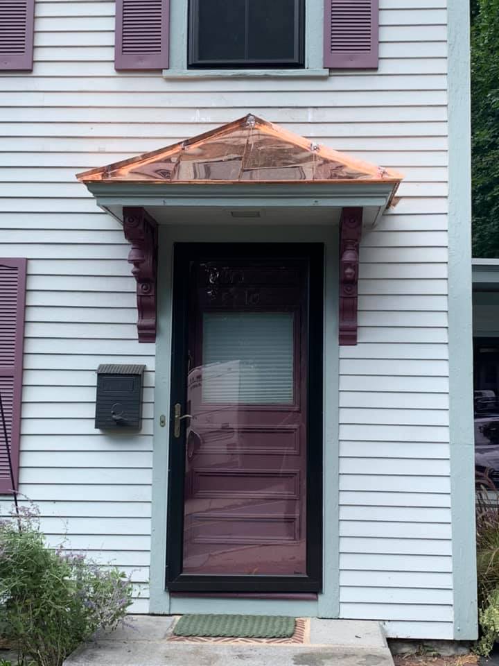 A white house with purple shutters and a black door