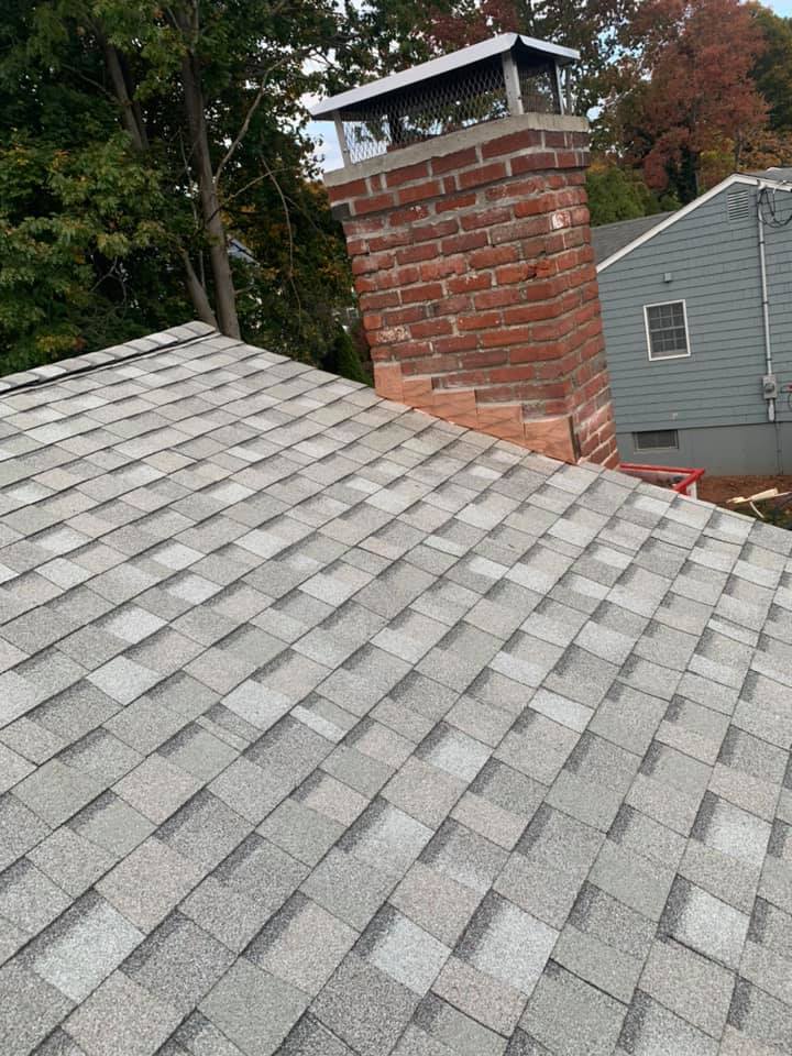 A roof with a brick chimney on top of it.