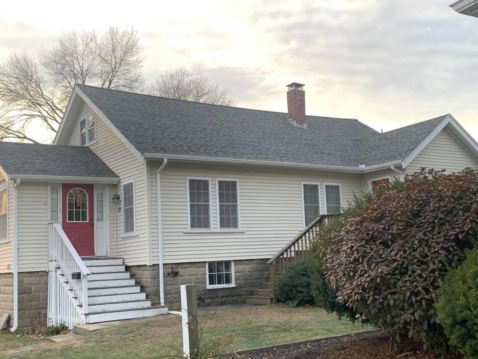 A white house with a red door and stairs