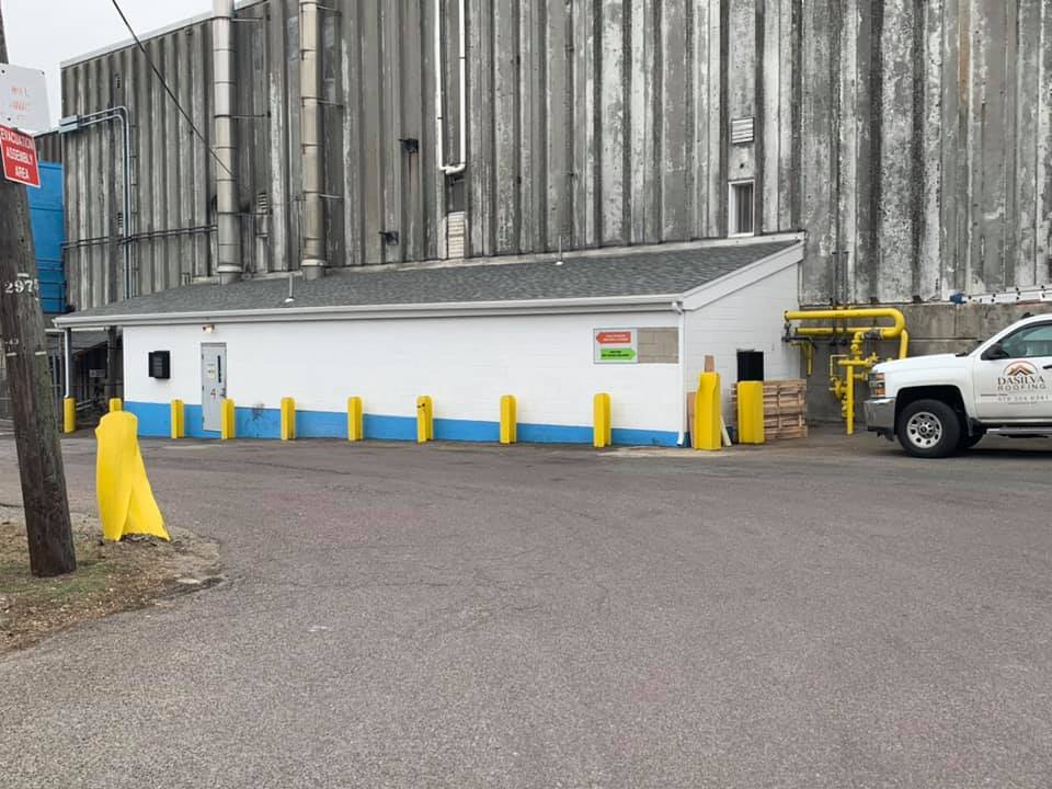 A white truck is parked in front of a building