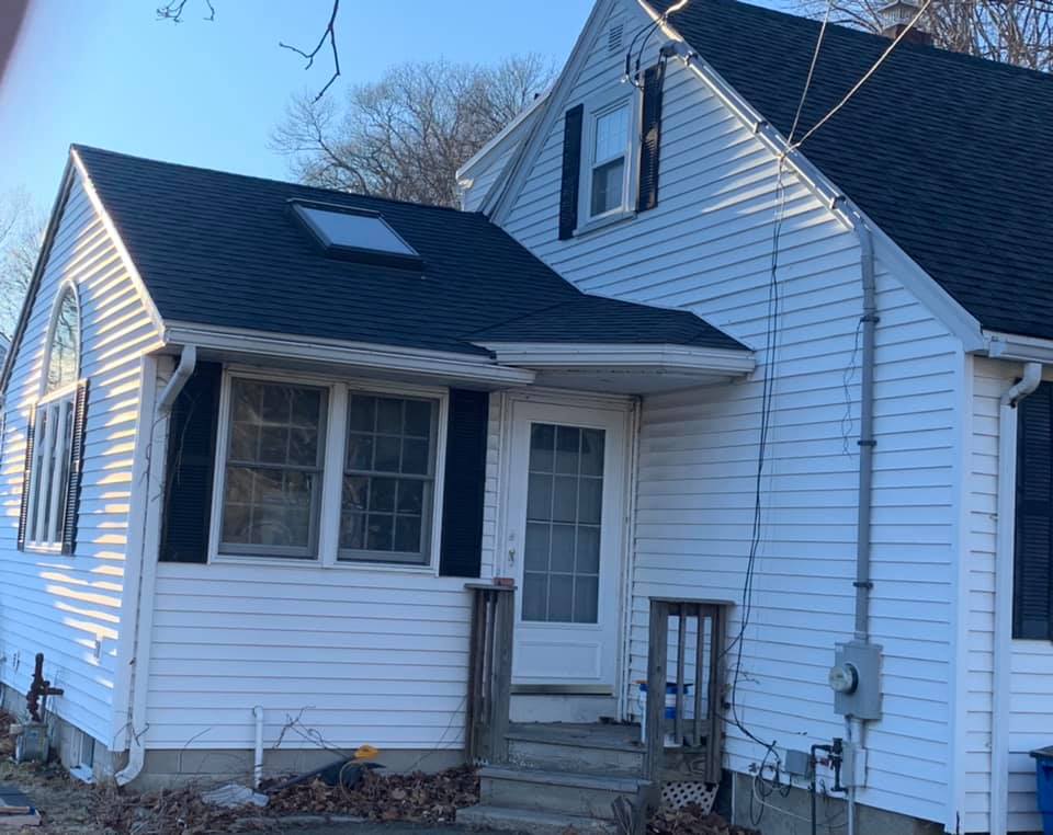A white house with a black roof and black shutters