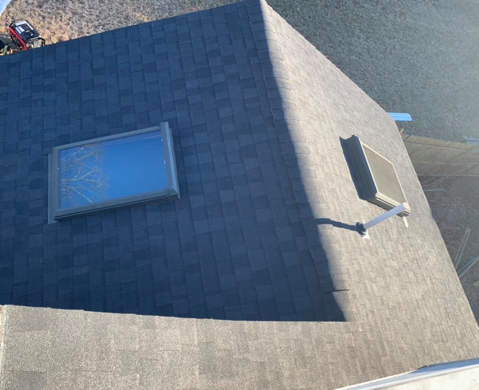 A roof with a skylight and a satellite dish on it.