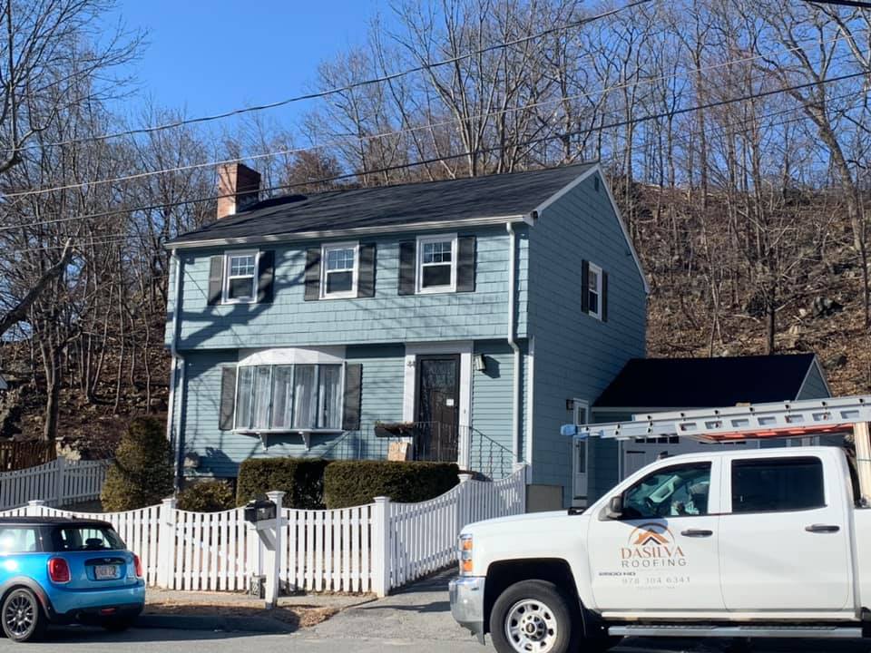 A white truck is parked in front of a house.