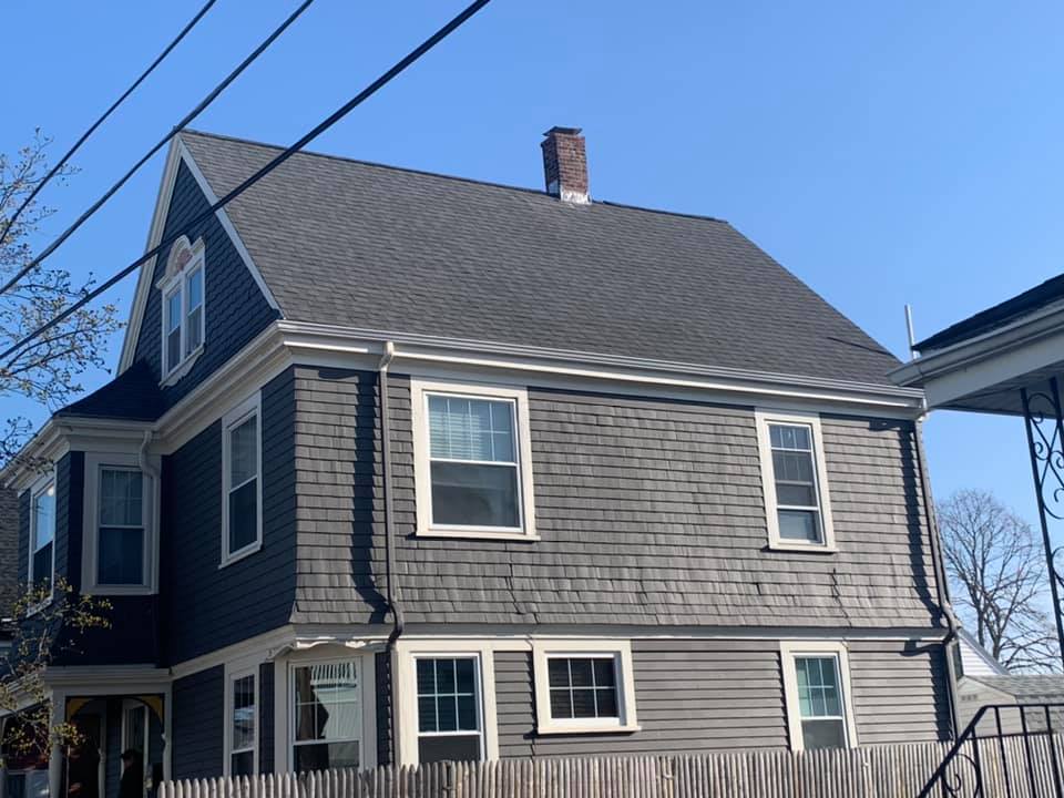 A large house with a gray roof and white windows