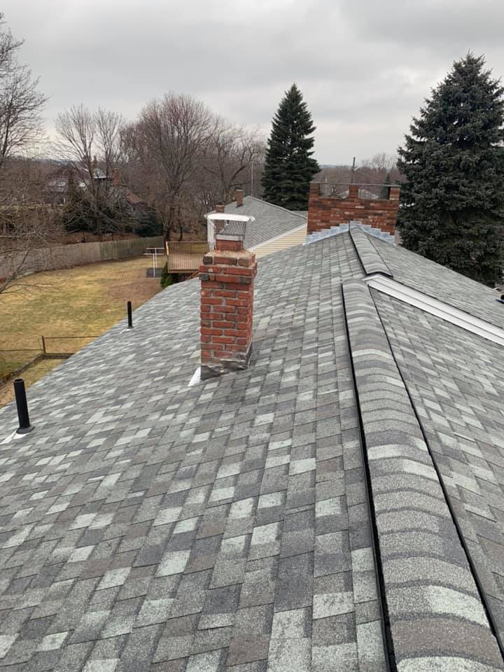 There is a chimney on the roof of a house.