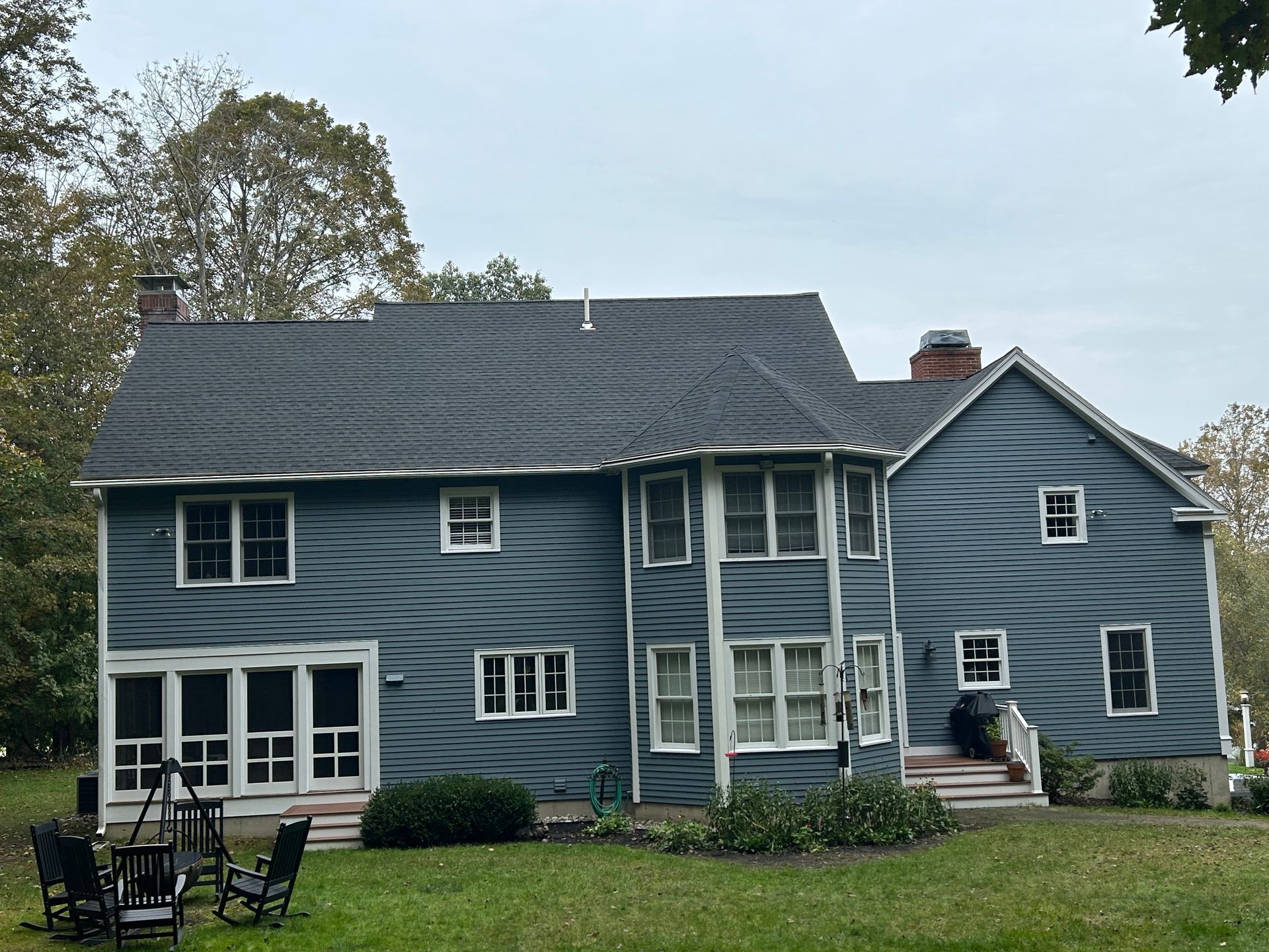 A large blue house with a large lawn in front of it
