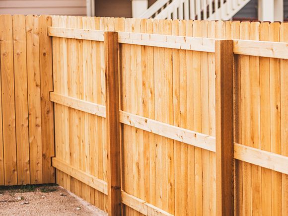 a wooden fence is sitting in front of a house .