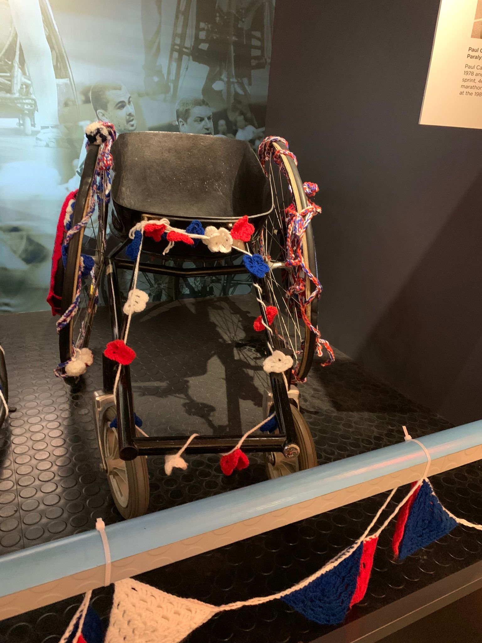 Wheelchair that has a bucket seat to allow athletes to race. Black tin seat, black wheels. 