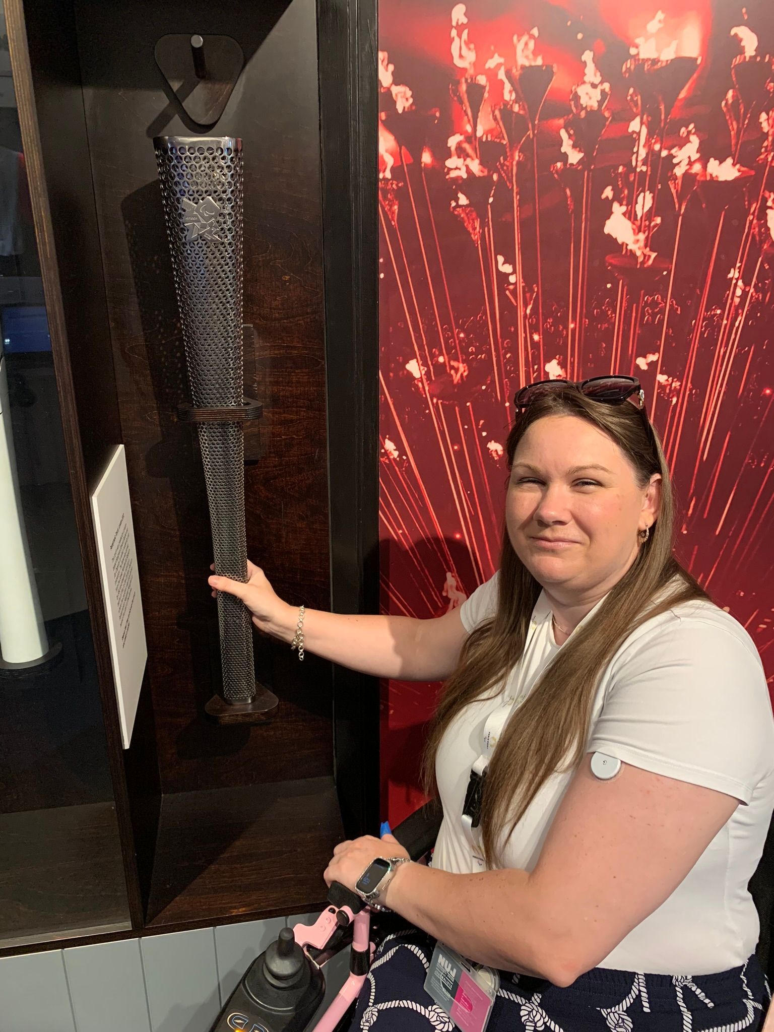 Victoria-Jayne in a white t-shirt, holding a long silver flame in her left hand. 