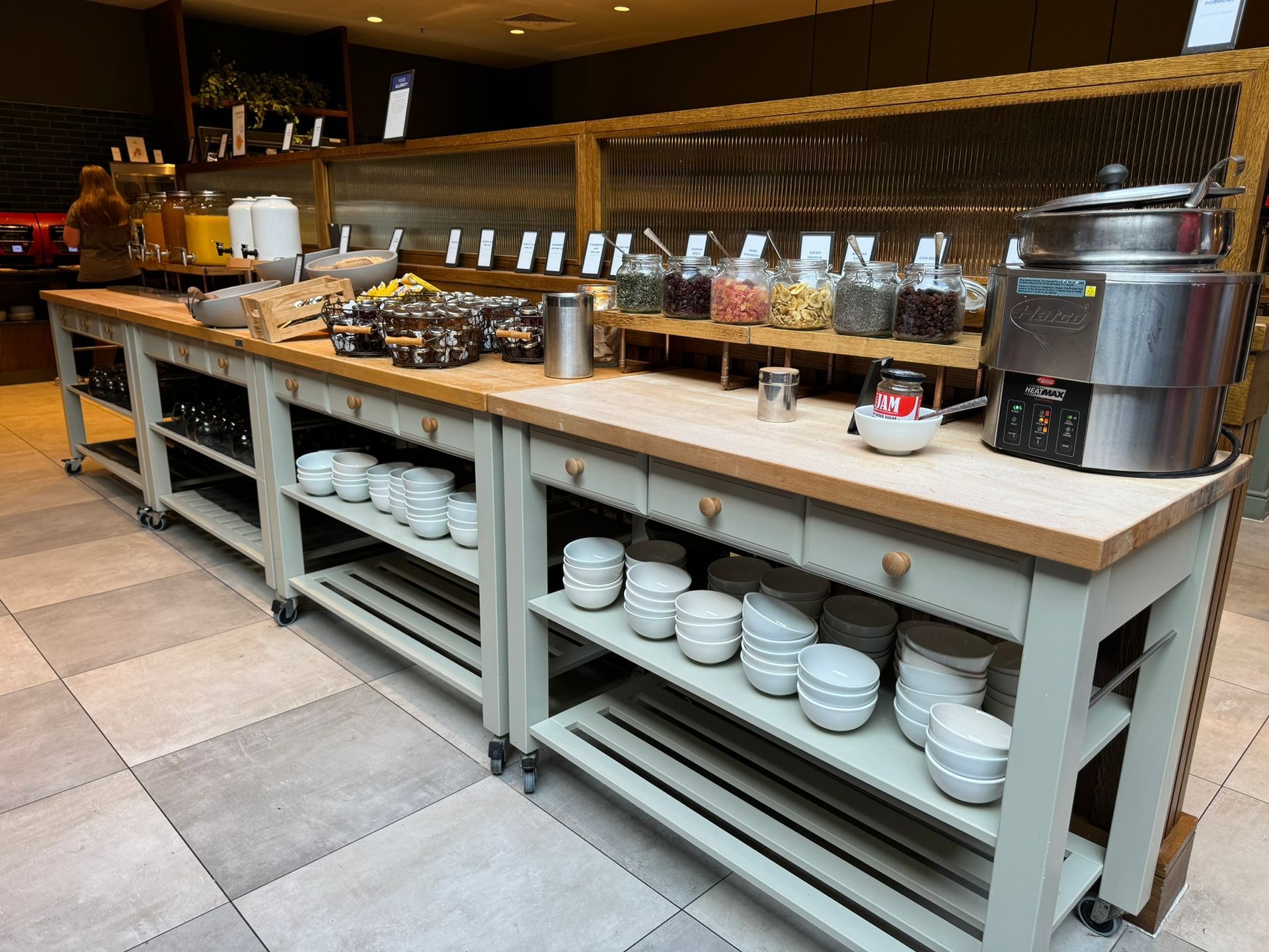 A white sideboard holds a selection of fruit juices, cereals and milk. 