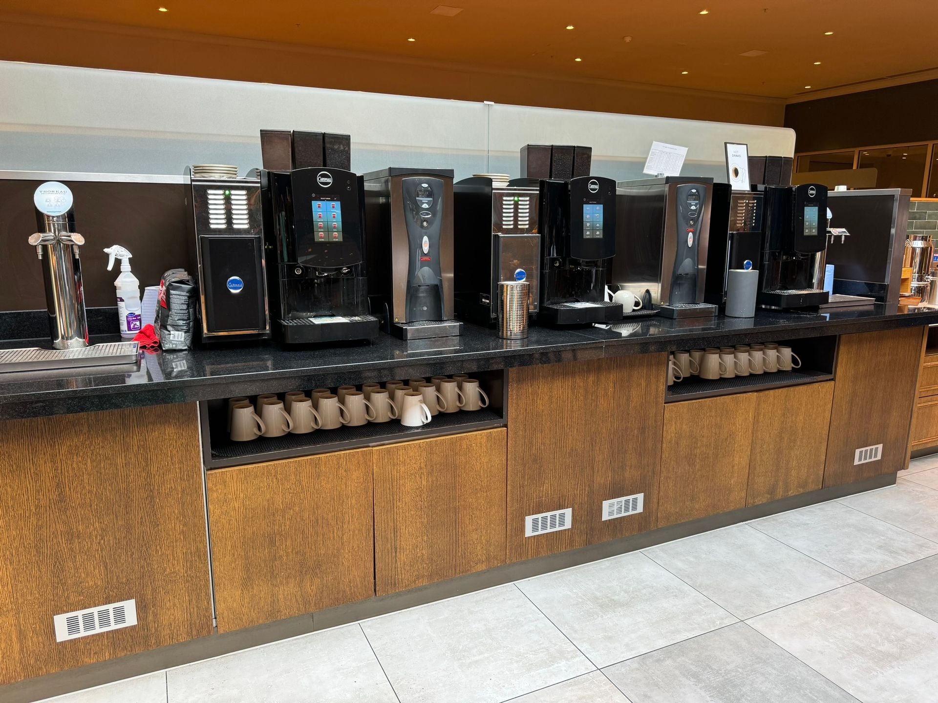 An oak side board holds a range of coffee machines as well as a variety of teas and cups. 