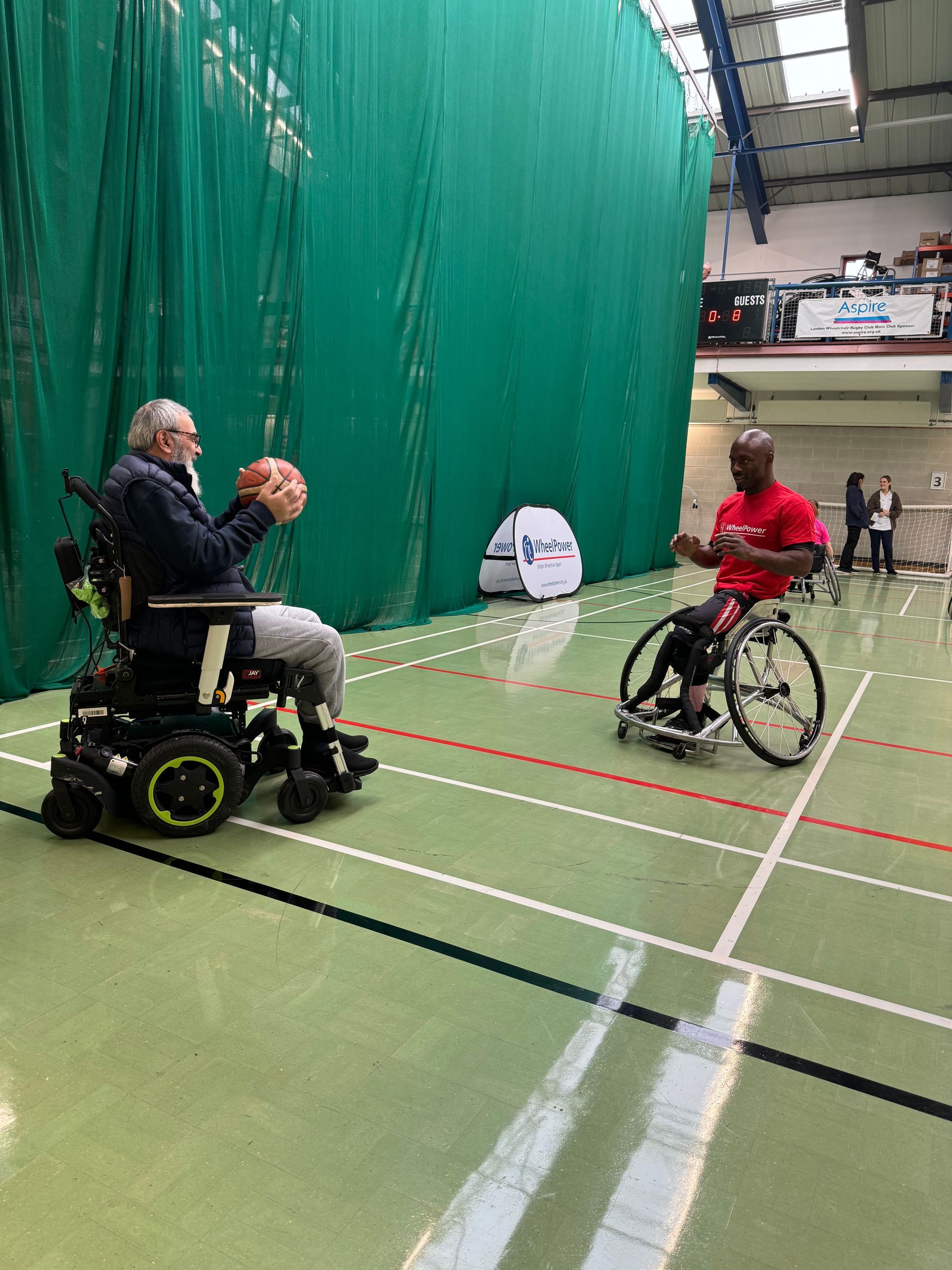 Titan player and participant practising baskball skills from their wheelchair. 