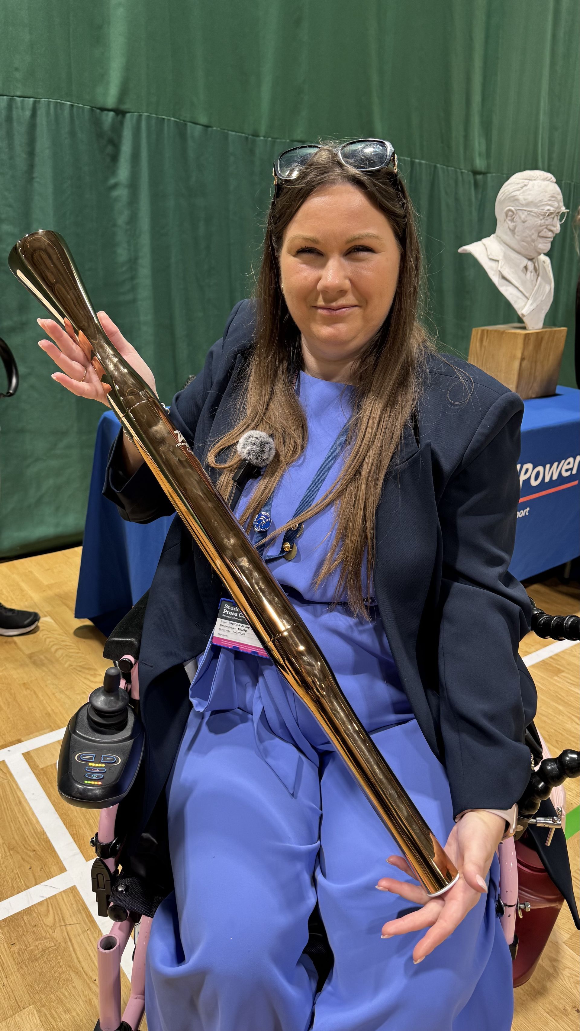 Victoria-Jayne wearing a blue jumpsuit and navy blazer with long brown hair and sunglasses on