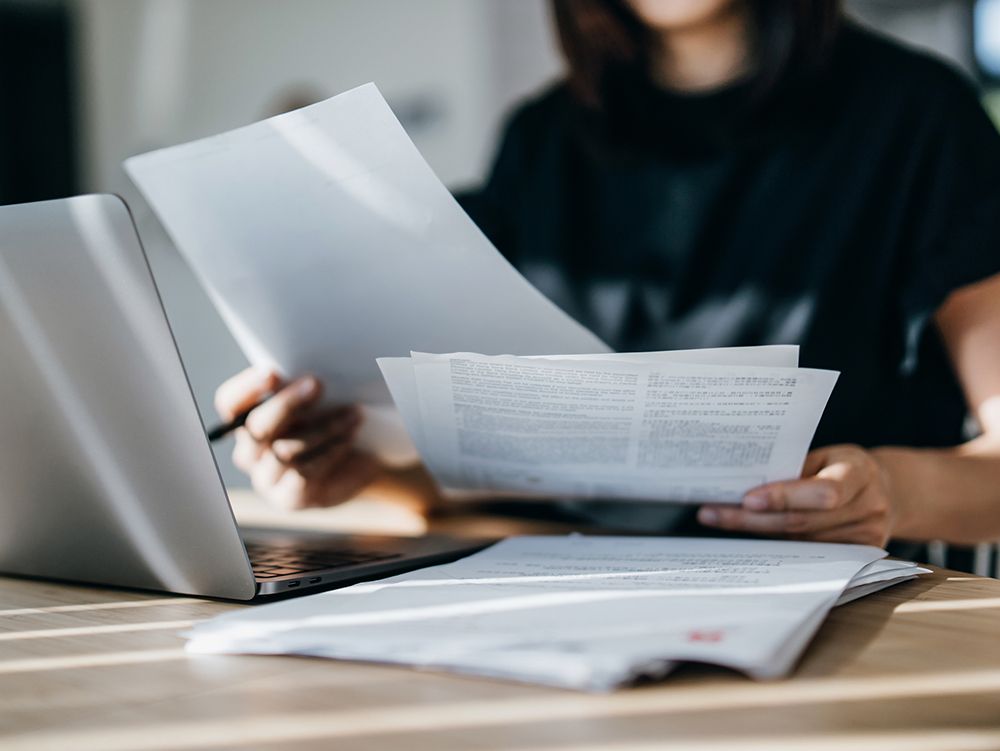 Young Asian woman managing personal insurance documents, close-up. Personal finance and insurance pl