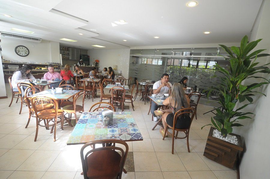 Um grupo de pessoas está sentado às mesas de um restaurante.