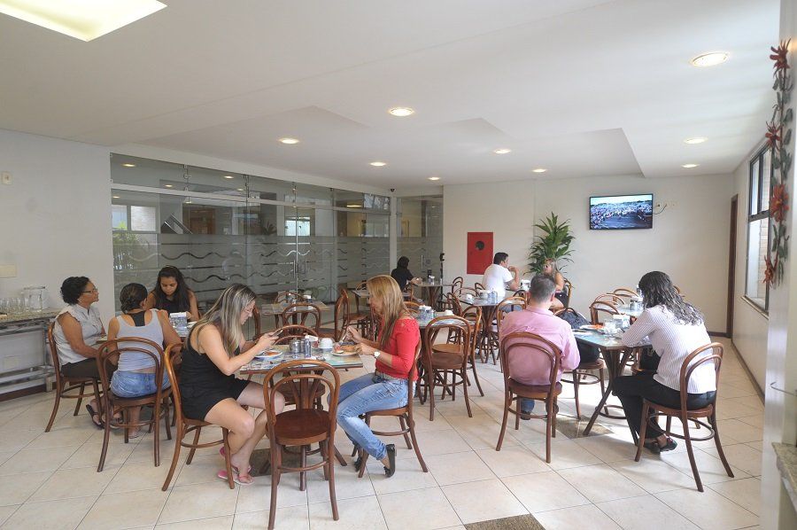 Um grupo de pessoas está sentado às mesas de um restaurante.