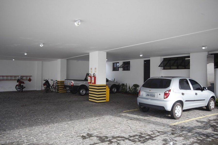 Um carro branco está estacionado em uma garagem.