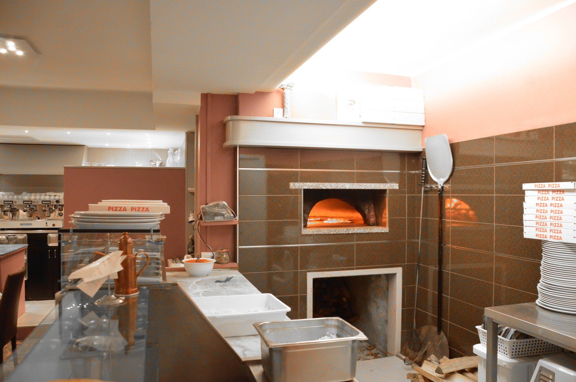 Un forno per pizza in una cucina con dentro scatole di pizza