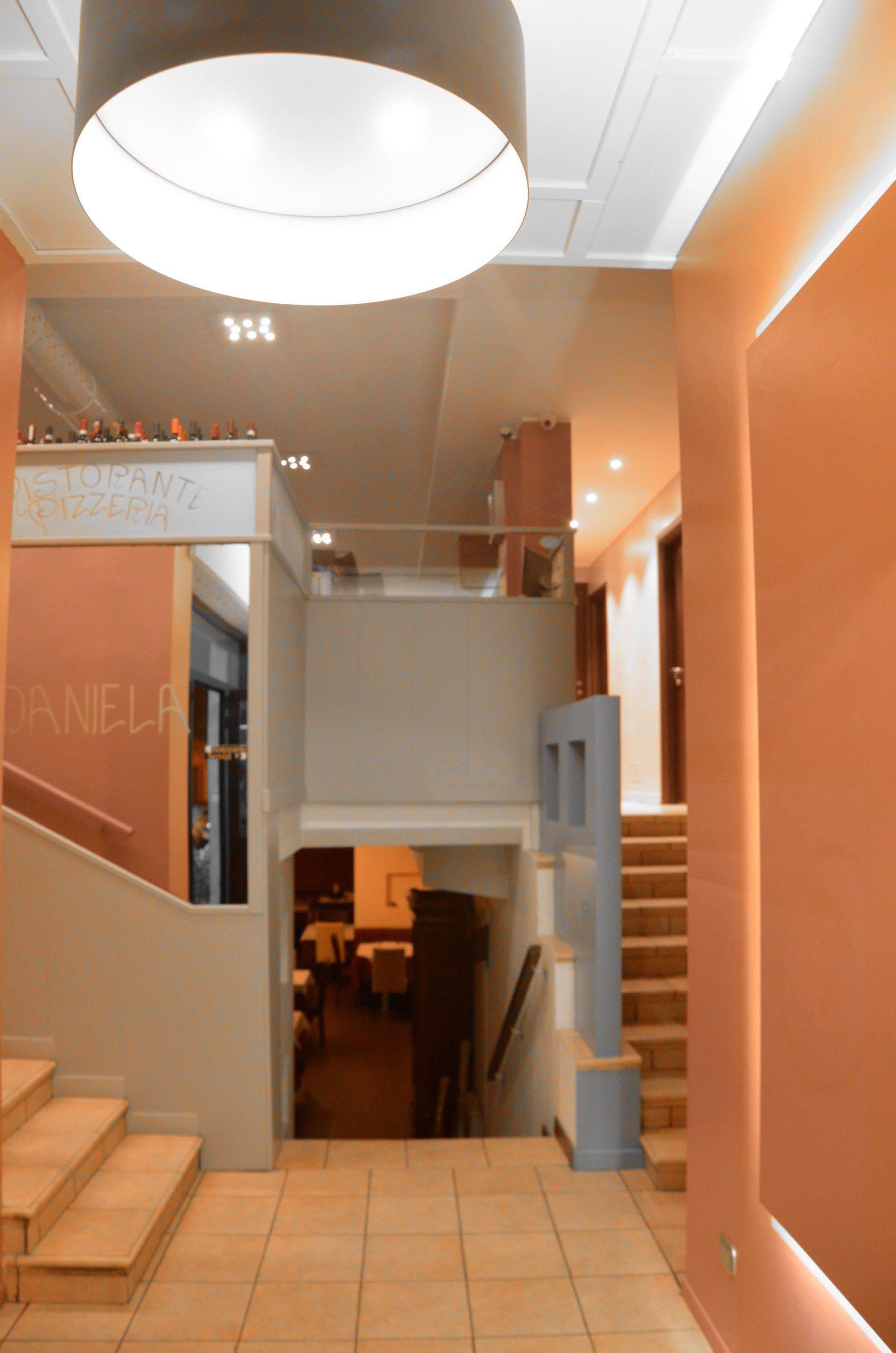 Un corridoio con scale e una grande luce appesa al soffitto