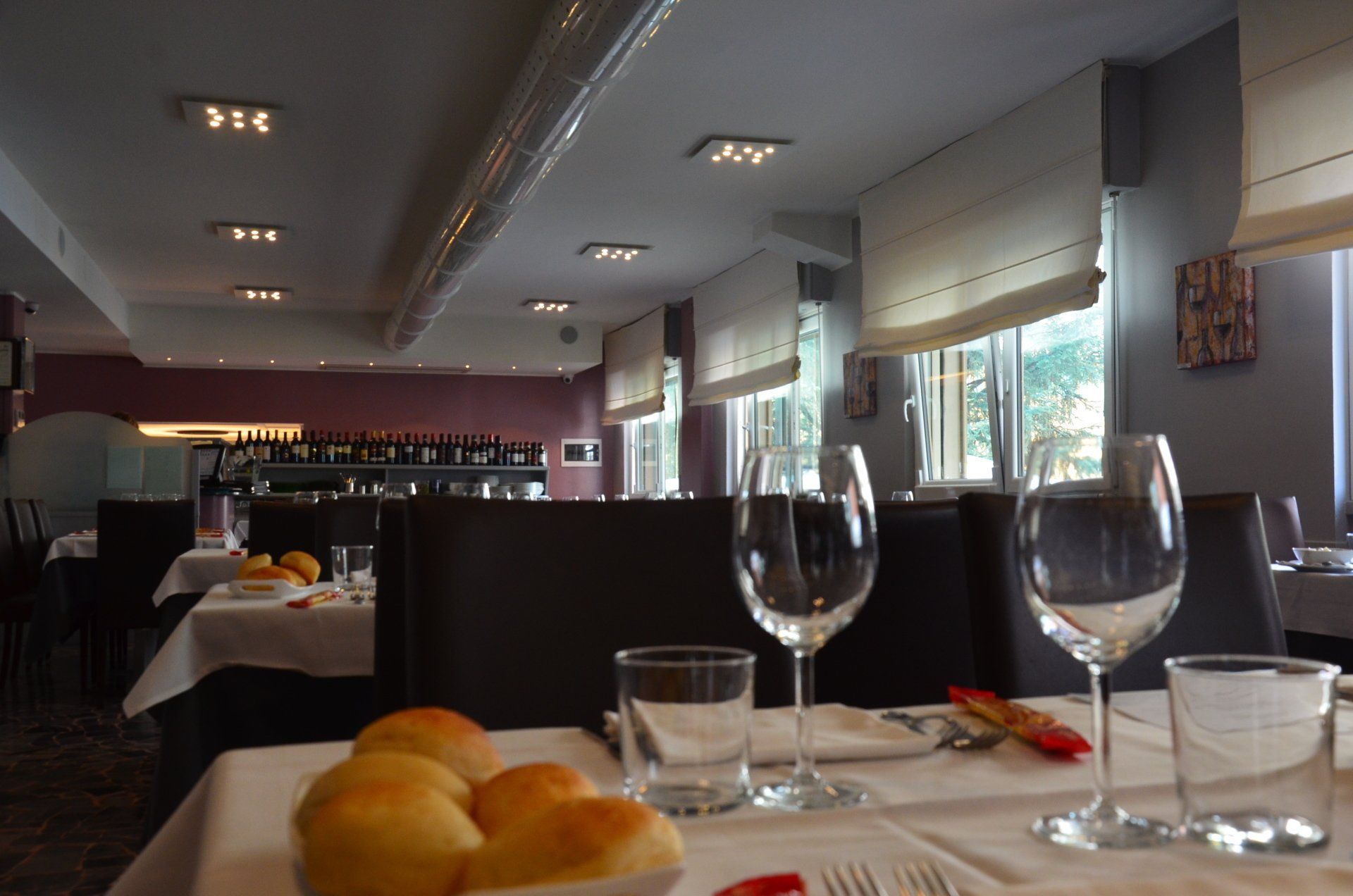 Un ristorante con un mucchio di pane e bicchieri di vino sul tavolo